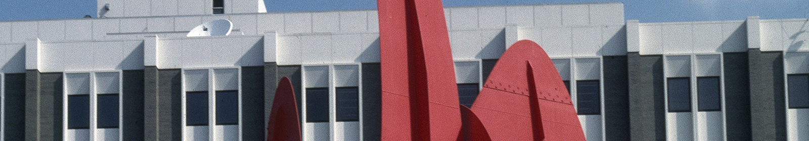 Photograph of an abstract red metal shape in front of a building
