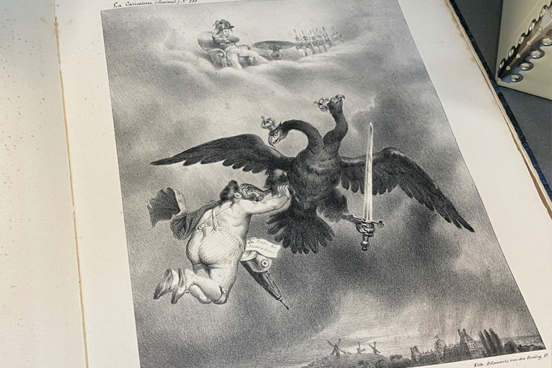 A black and white drawing shows a two-headed eagle bearing a sword in one hand and carrying a partially clothed man in the other. Above them in the clouds sits a man wearing a plumed hat. 