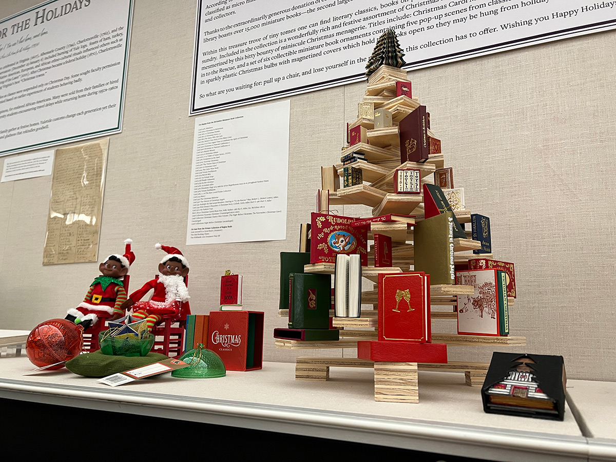 Miniature books arranged on a small wooden stand to look like a Christmas tree. 
