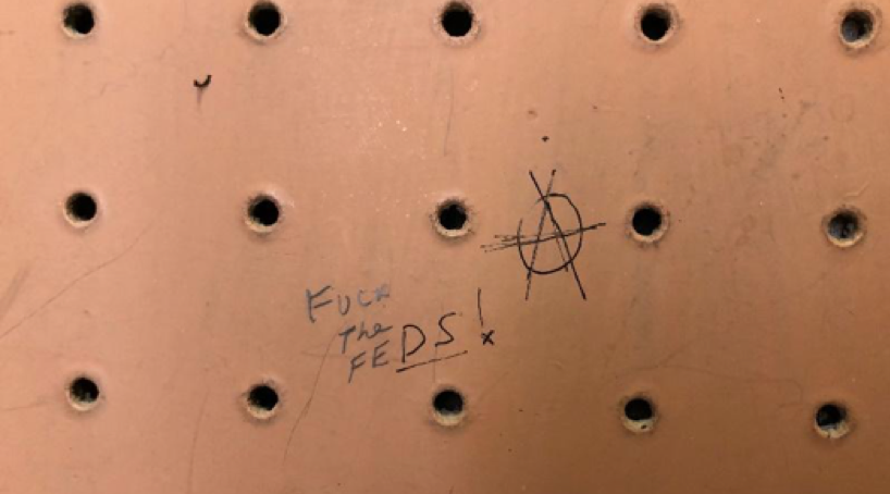 Handwriting on a pegboard reads: Fuck the feds!