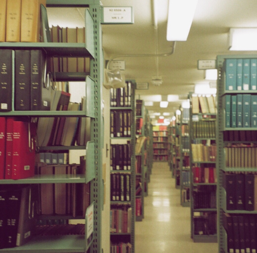 A view down the corridor of book stacks, shelves on either side