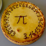 A lemon pie with the number/mathematical constant pi (3.14159 ...) written in frosting around the border/circumference of the pie.