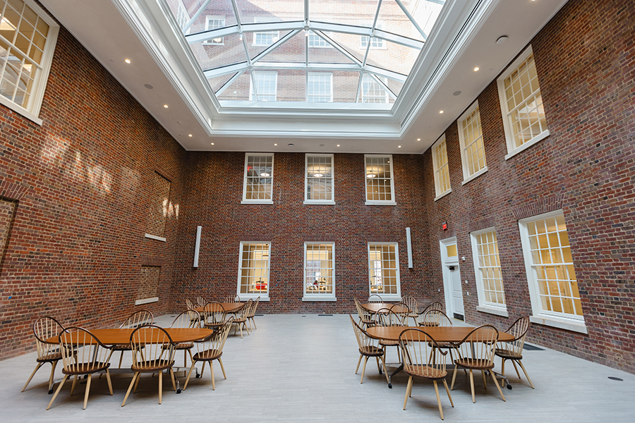A large study area in a brick-enclosed courtyard space under a massive skylight.